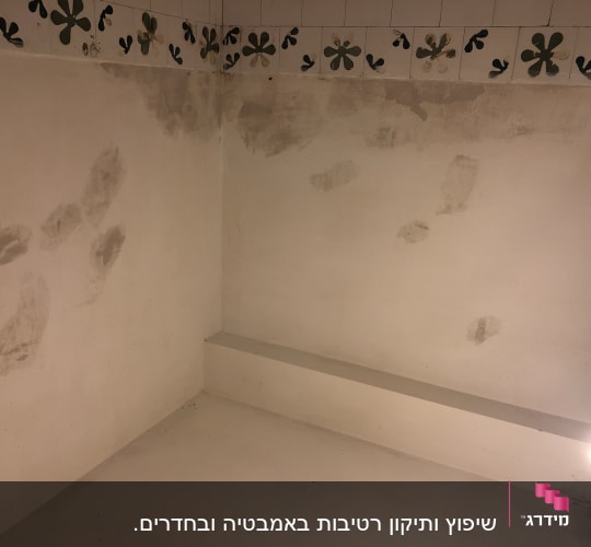 קיר עם כתמי צבע ותיקונים, אריחים מעוטרים בחלק העליון